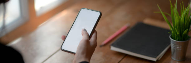 istock Cropped shot of female freelancer using blank screen smartphone in simple workspace 1216327276