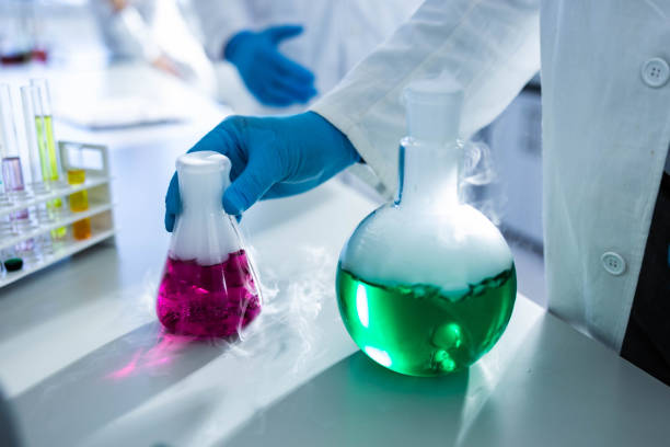 istock Close up of taking smoking laboratory flask with purple liquid. 1216330813