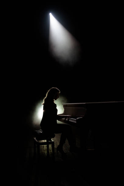 istock Female keyboards player on stage during concert, backlight 1216330962