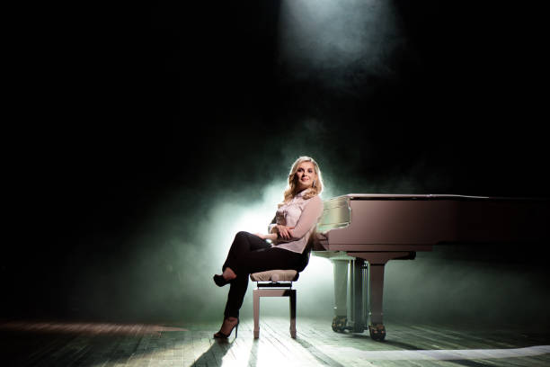 istock Pianist posing near white piano on the stage 1216331008