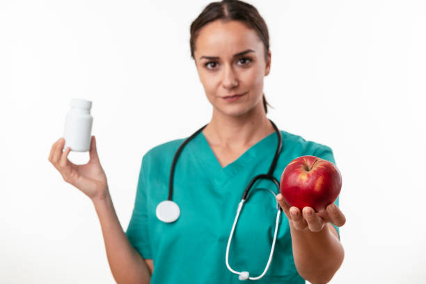istock Young nurse with stethoscope giving an apple. 1216331954