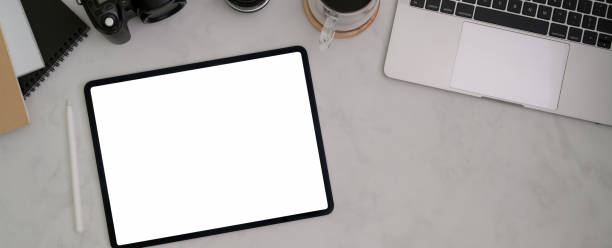 istock Top view of comfortable workspace with blank screen tablet, laptop, supplies and copy space 1216332383