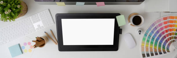 istock Overhead shot of graphic designer office desk with blank screen graphic tablet on white table 1216332427