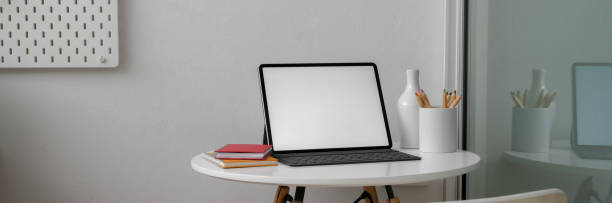 istock Close up view of portable workspace with mock-up tablet, notebooks and ceramic decorations 1216332486