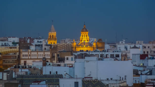 Cathedral of Sevilla Great Gothic cathedral with the tomb of Columbus and an Arab-style bell tower overlooking the city. Photograph taken at sunset with the Cathedral illuminated santa cruz seville stock pictures, royalty-free photos & images