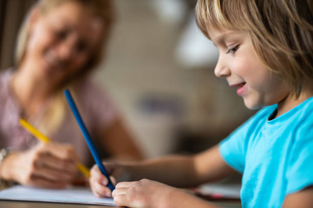 istock Happy little boy enjoying while coloring with crayons at home. 1216334836