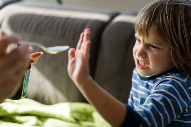 istock Angry little boy refusing to drink medical syrup at home. 1216334868