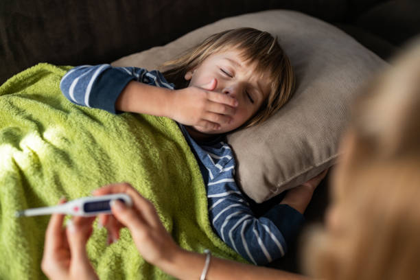 istock Ill little boy coughing while having a fever from corona virus. 1216335014