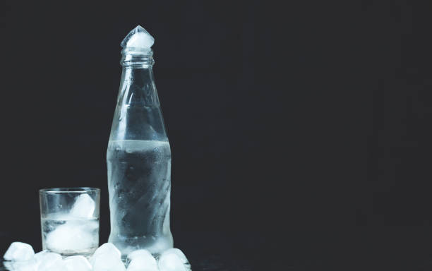 istock Bottle with glasses of vodka on black background. 1216337353