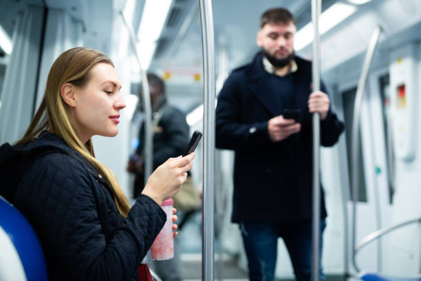 istock Girl using mobile phone in metro car 1216344924