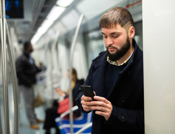 istock Young man with phone in subway car 1216344968