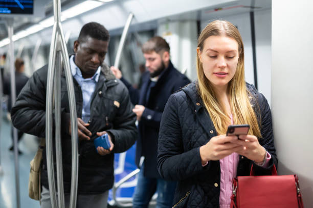 istock Young woman with phone in subway car 1216344971