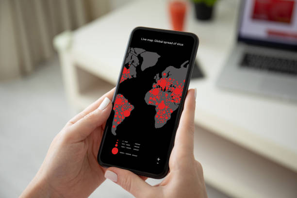 female hands holding phone with live map global spread virus