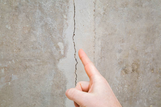 dedo da mão do homem apontando para o teto rachado. construindo problemas e conceito de solução. closeup. - sólido - fotografias e filmes do acervo