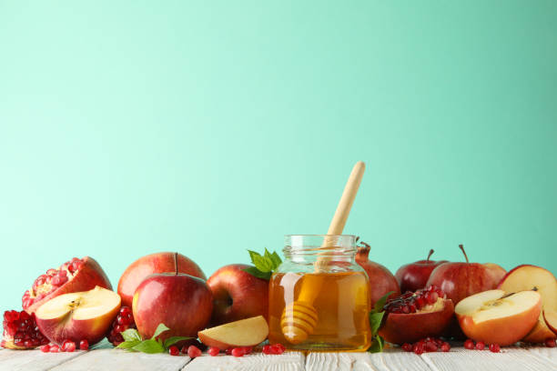 istock Apples, pomegranate and honey against mint background, space for text 1216349926
