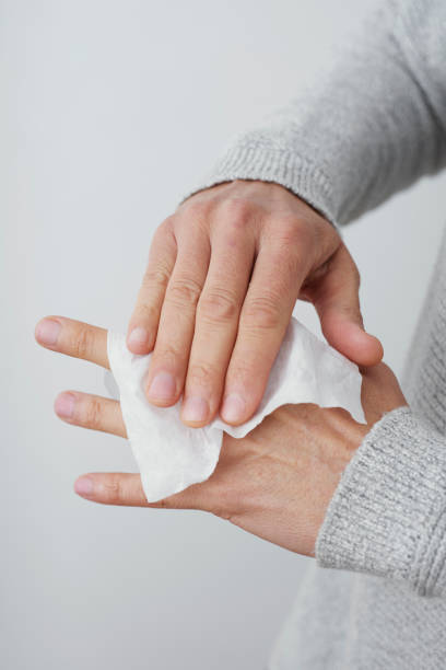 istock man cleaning his hands with a disinfecting wipe 1216351076