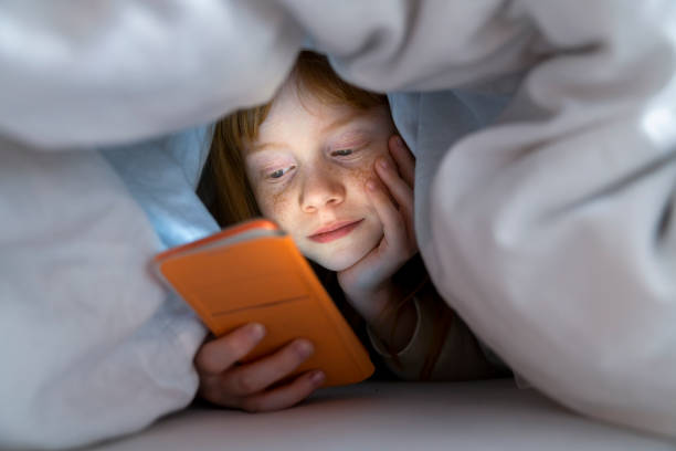 istock Young girl using social media on mobile phone in bed 1216351872