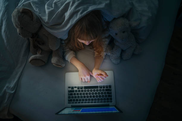 istock Top view of small girl using computer in bed. 1216351960