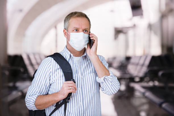 istock Man in protective mask standing in airport hall 1216352141
