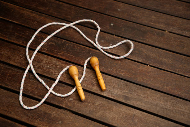 An old skipping rope on a wooden deck. Exercising at home concept image.