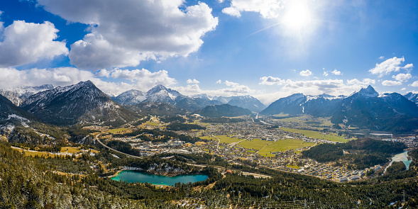 Panorama of circular deep valley basin of Reutte and Breitenwang with lake Urisee at sunny spring day