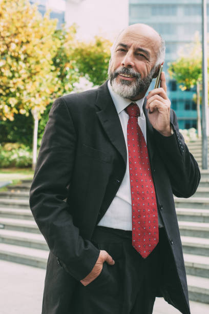 istock Content businessman talking by smartphone and looking at camera 1216359806