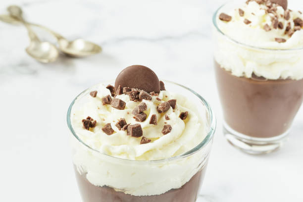istock Chocolate mousse and cream cup for a restaurant menu with spoons on white marble background. 1216360466