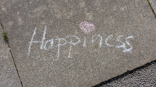 istock Word Happiness written on pavement with white chalk. 1216361131