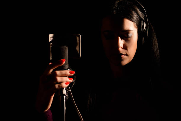 istock Female vocal artist singing in a recording studio. 1216362320