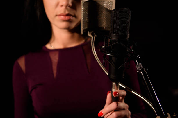 istock Young woman singer in front of microphone. 1216362513
