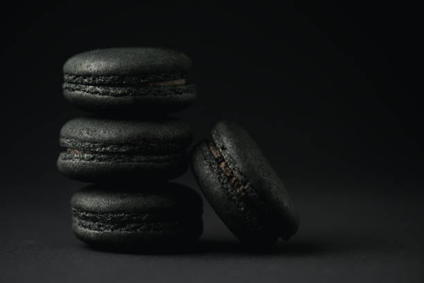 istock tasty and dark macarons on black with copy space 1216365432
