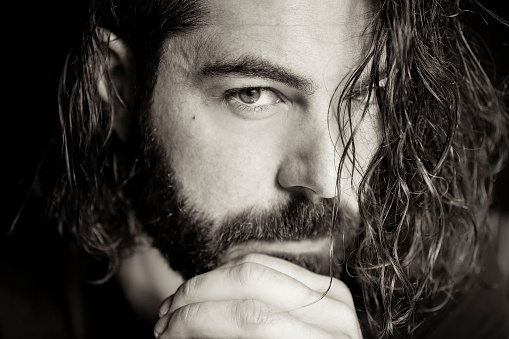Beautiful caucasian, bearded, long haired man in black and white