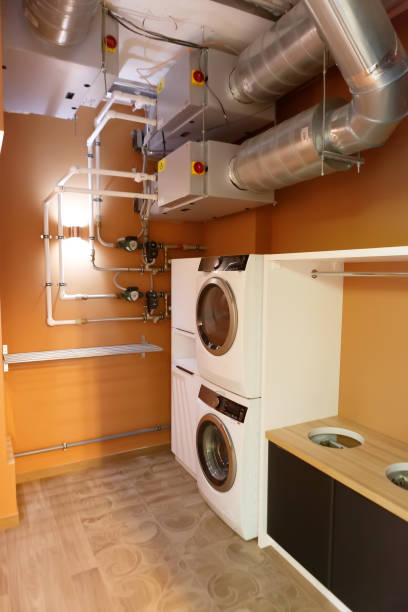 istock Utility room with two washing machines. There are large pipes on the ceiling. 1216368875