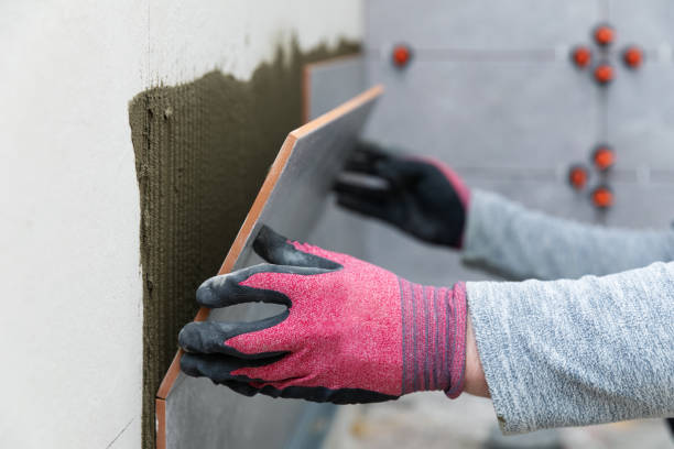 istock tiler laying tiles on the bathroom wall 1216369407