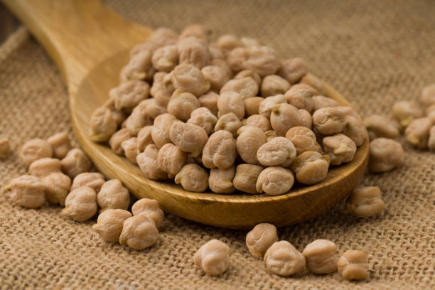 istock chickpeas over wooden spoon on sackcloth background. Close up 1216371120