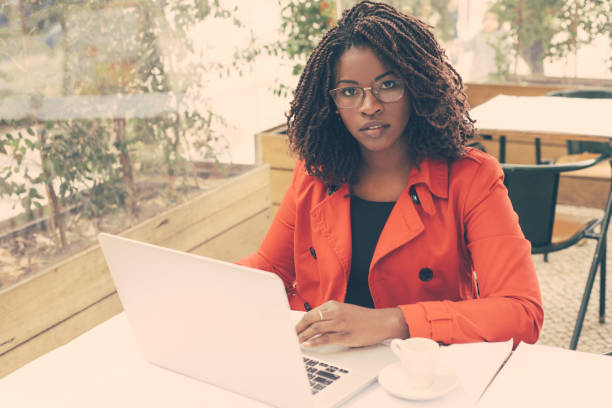 istock Serious woman using laptop and looking at camera 1216371725