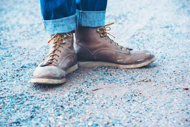 istock Boots safety worker at construction site. Engineer Wear Jeans And Brown Boots for Worker Security on Background of Refinery. Engineer safety industry fashion foot walking outdoor. 1216381665