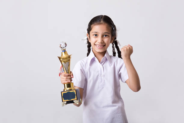 istock Schoolgirl holding trophy and celebrating success 1216381721