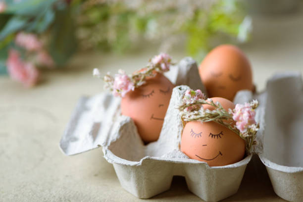 istock Natural easter eggs with funny painted face and sweet flower wreath 1216383084