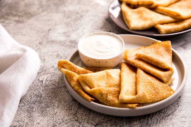 istock Traditional Russian pancakes. Fried crepes with sour cream 1216383330