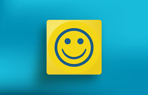 Yellow cube with Smiley icon on blue background. Horizontal composition with copy space.