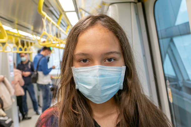 istock Young tween girl wearing surgical mask on subway 1216385659