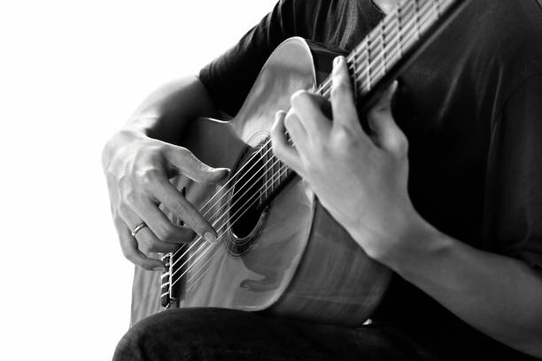 Close-up women playing acoustic guitar on walking street.