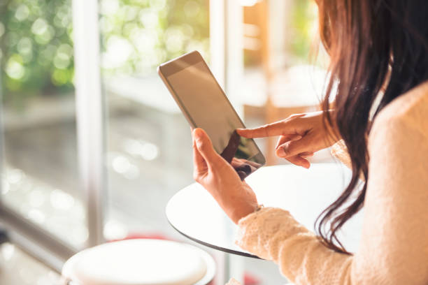 istock Asian woman using tablet shopping online website on smart tablet hand point touch screen digital tablet. Woman holding smartphone checking mail online shopping website read article vlog social media 1216387042
