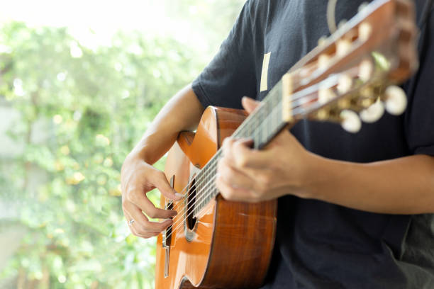 istock Man playing classic guitar in door with blur background. 1216388469