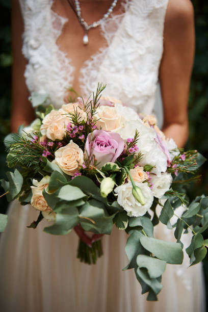istock Bride stands outside with a bouquet 1216389619