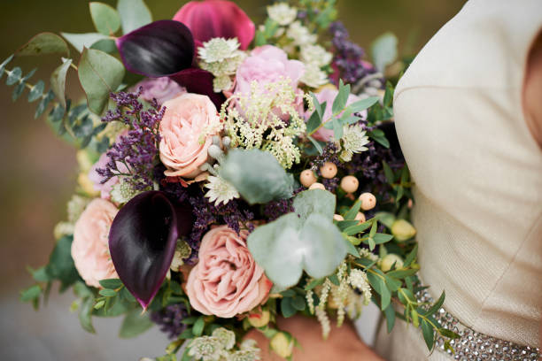 istock Bride in beige dress holds a wedding bouquet in her hands 1216389708