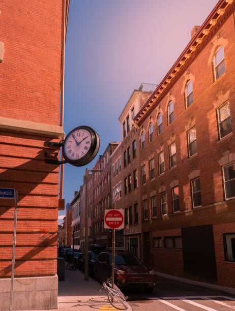 istock Red brick buildings and large round clock on the wall on empty street 1216389895