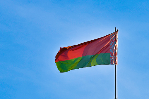 Belarusian flag on sky background. Develops in the wind. Flag of Belarus