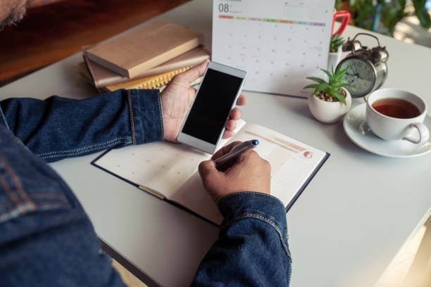 istock Male hand of planner writing daily appointment 1216391701